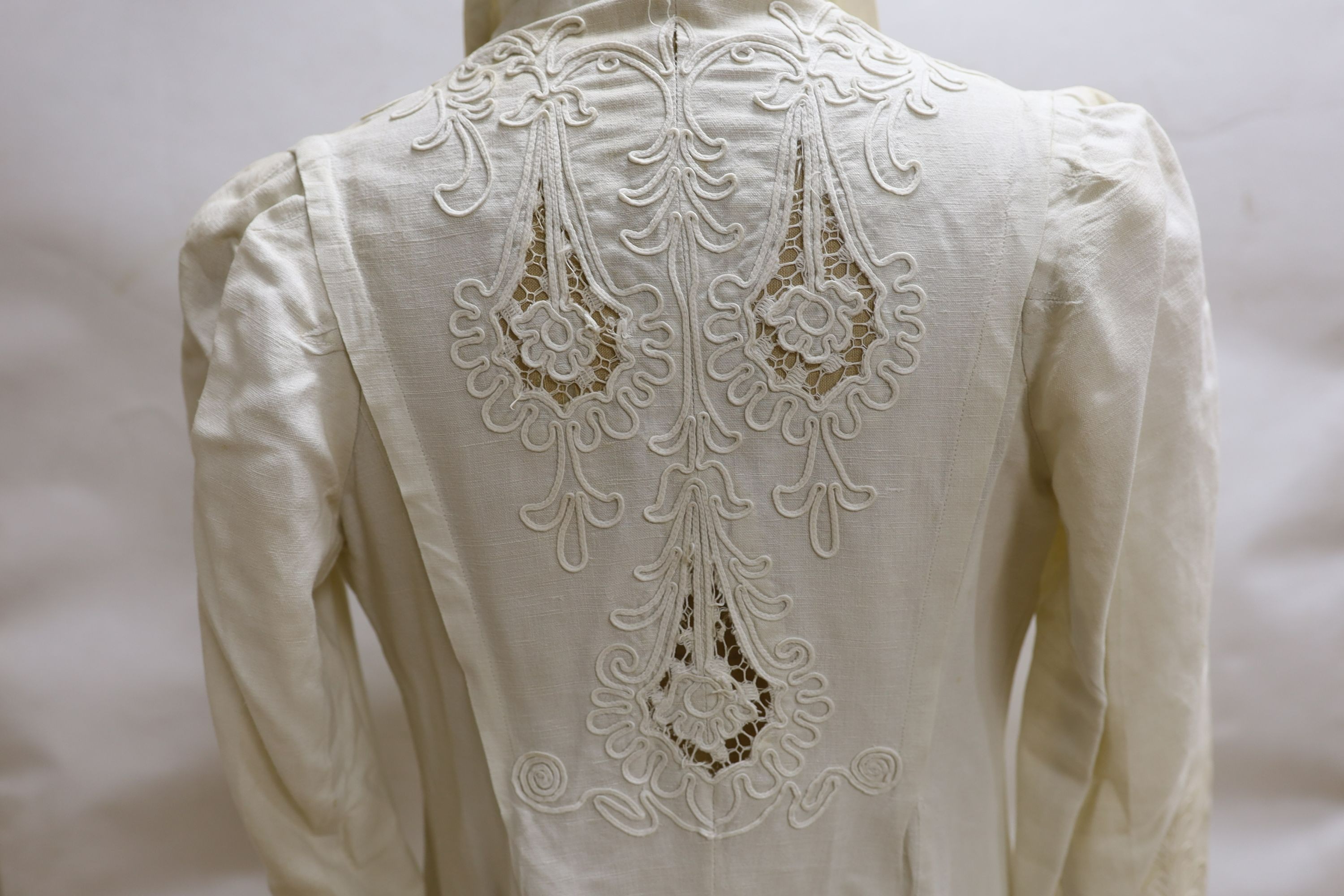 An Edwardian white/cream linen lady's coat with cut work detail and unusual button detail to the back